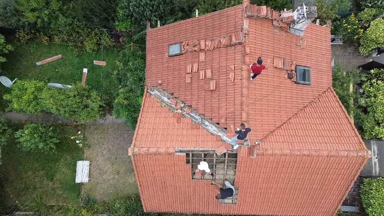 Vue aérienne de la pose de tuiles neuves lors d'une rénovation à Igny